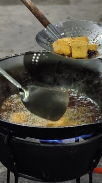 Frying Tofu and catfish in a pan. Traditional Indonesian food.