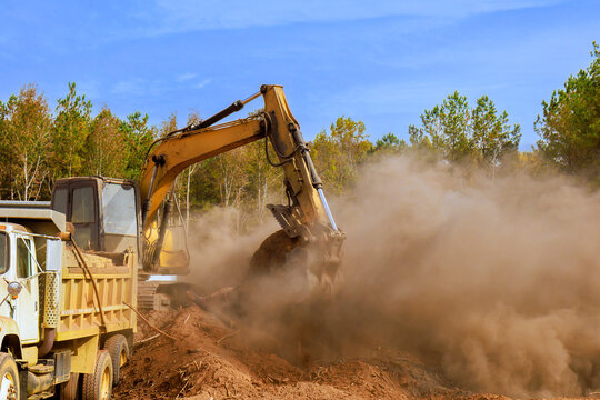 Heavy machinery clears soil tree removal, at construction site, creating dust cloud work in progress deforestation