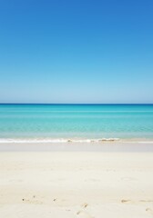 Fototapeta premium Tranquil Beach Scene: Azure Ocean Meets White Sand Under a Clear Blue Sky
