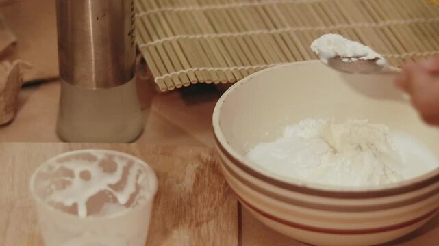 Adding a tablespoon of oil to a bowl of cornstarch, vinegar and glue mixture to make a DIY handmade air dry clay recipe for crafts
