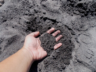 Playing With Black Sand On Beach