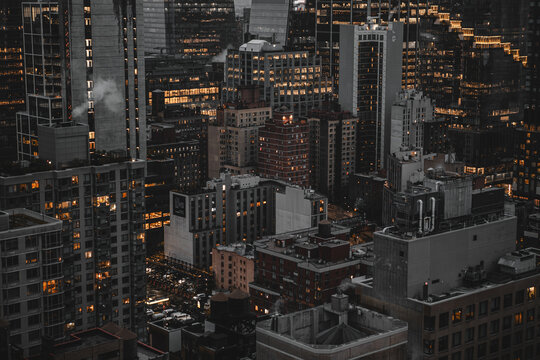 Nighttime New York City Skyline With Bright Urban Lights Across Tall Buildings and Rooftops