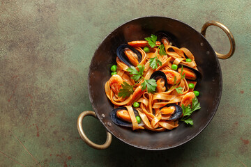 Tagliatelle pasta with mussels and shrimp in the bowl on the table. Mediterranean sea food cuisine