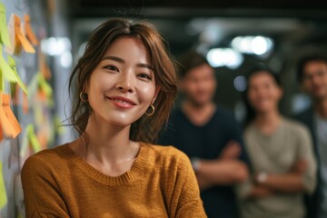 Confident asian female team lead presenting to coworkers during agile stand-up meeting sticky notes on whiteboard, collaborative mood, mixed gender group, casual modern workspace