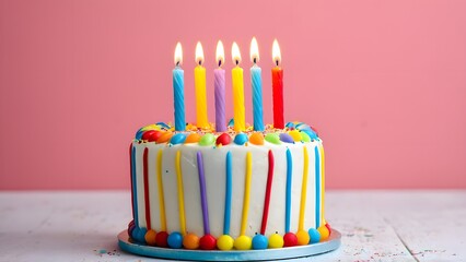 Colorful Celebration Cake with Candles on a Pink Background