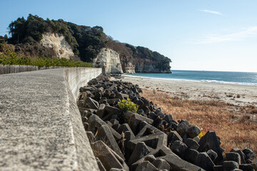 Tetrapods and Seawall at Iwama Beach, Iwaki City, Fukushima Prefecture, Japan, on a Clear Winter Day. Coastal defense structures with rocky shoreline and blue ocean under sunny sky &ndash; ideal for travel,