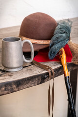 Feathered hat with a metal cup
