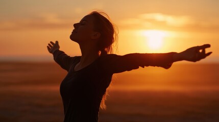 A graceful image of a woman breathing deeply at sunrise, arms wide open and body relaxed as she enjoys the fresh morning air.