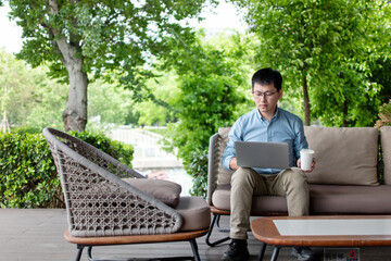 Fototapeta premium asian businessman working on smart phone outdoor
