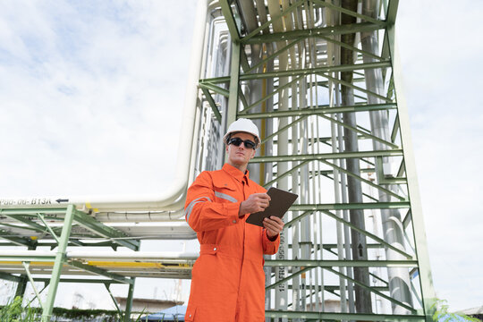 Petroleum refinery piping network system. Network of pipes, valves, pumps, mechanisms deliver natural gas. Petrochemical engineer inspecting, maintain, repair gas lines in natural gas separation plant