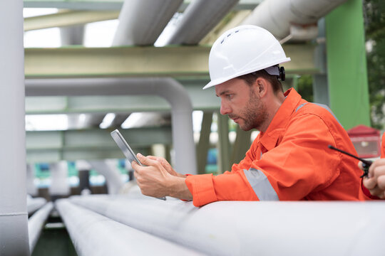 Petroleum refinery piping network system. Network of pipes, valves, pumps, mechanisms deliver natural gas. Petrochemical engineer inspecting, maintain, repair gas lines in natural gas separation plant