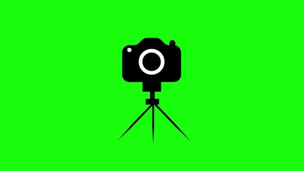 A black and white camera on a tripod against a vibrant green backdrop perfect for photography and video concepts and themes