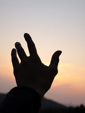 a woman hand doing ok perfect sign at sunset