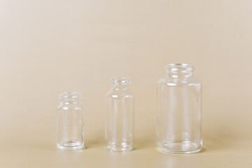Three empty glass vials of varying sizes stand in a row