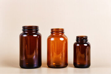 Three amber glass bottles of varying sizes stand in a row