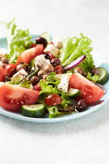Healthy and tasty salad with feta cheese, various tomatoes, olives, cucumber, onion and lettuce.