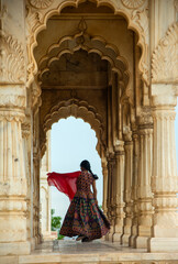 Naklejka premium Young female tourist dancing between arches and Pillars.