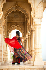 Naklejka premium Young female tourist dancing between arches and Pillars.