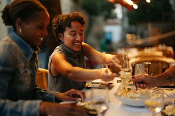 Friends sharing food at a restaurant table, enjoying a meal together