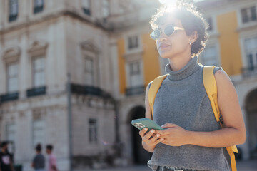 Young tourist using smart phone in lisbon, portugal, exploring european city