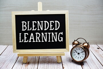 Blended Learning text written on chalkboard with alarm clock on wooden background