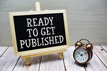Ready To Get Published text written on chalkboard with alarm clock on wooden background