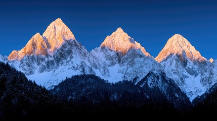 Snow capped mountain peaks illuminated by the warm morning sunlight