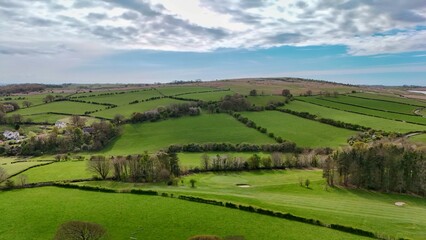 Drone view over spring patchwork farmland and hills