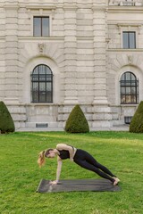 A young woman engages in yoga outside, in a stunning and picturesque setting, beautifully demonstrating both her strength and grace as she moves through her exercise routine with poise and ease