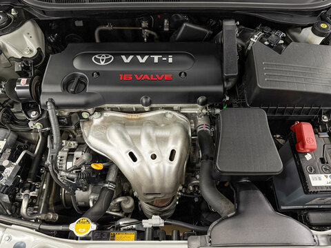 Close up the engine bay on a Toyota Camry Head cover on the block with the Toyota logo and VVT-i technology. The engine room of all Toyota Camry showing the VVT-I engine.
