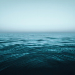 Obraz premium Dark teal ocean surface with gentle ripples meets a muted, low horizon under an overcast sky, ideal for a moody website header or editorial visual.