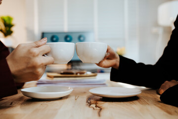 Young adults enjoy coffee and conversation at a cozy café, sharing laughter, bonding, and relaxation in a warm, friendly atmosphere indoors.