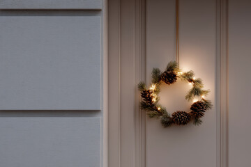 minimalist christmas wreath adorned with soft warm lights elegantly hanging on wooden door