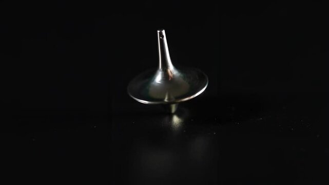 Metallic Top Spinning on Black Surface