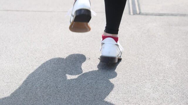 屋外で歩く男性の足元のイメージ