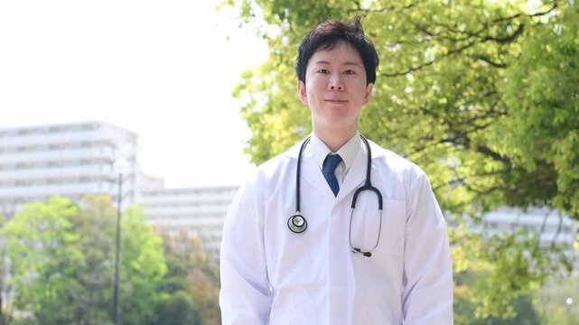 お辞儀をする白衣のアジア人の男性医師