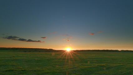 A breathtakingly beautiful sunrise over a stunning green field landscape that captivates Time lapse.