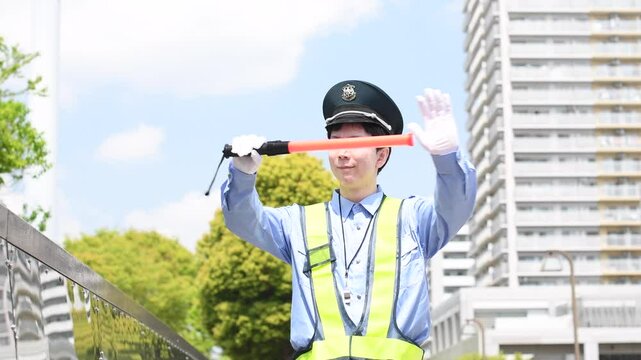 屋外で交通整理をする交通誘導員の若い男性
