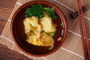 Dumplings and hot soup in a wooden bowl ready to eat
