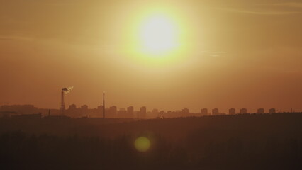 Fototapeta premium An industrial sunset glows over the cityscape, blending natures tranquility with urban life
