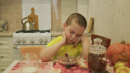 A Thoughtful Child Sitting at the Breakfast Table Enjoying a Bowl of Cereal This Morning