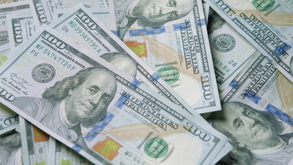 A closeup view of United States currency featuring multiple hundred dollar bills stacked together