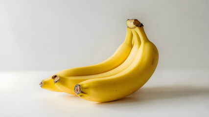 A bunch of fresh ripe yellow bananas presented on a clean white surface