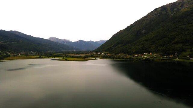 Aerial Upward Scenery Of Rippled Plav'S Lake By Mountains Against Clear Sky