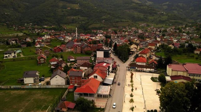 Aerial Tilt Up Scenic Shot Of Houses In Residential Town By Mountains Against Clear Sky - Plav, Montenegro
