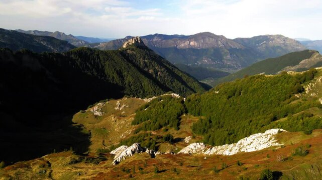 Aerial Tilt Up Forward Shot Of Green Plants On Tranquil Mountains Under Clouds In Sky - Plav, Montenegro