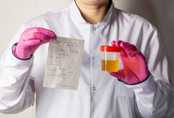 The doctor holds in his hands a direction for tests and urine. The concept of taking tests in urology for cystitis, pyelonephritis and prostatitis. Kidney disease, close-up