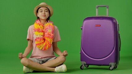 Traveler Meditates Peacefully Beside Her Vibrant Suitcase