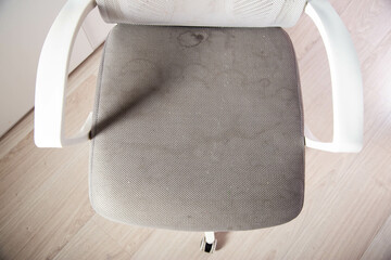 Dirty gray computer chair with stains on upholstery fabric, dry cleaning, close-up