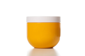 Yellow jar with restorative and nourishing hair mask on a white background, isolate